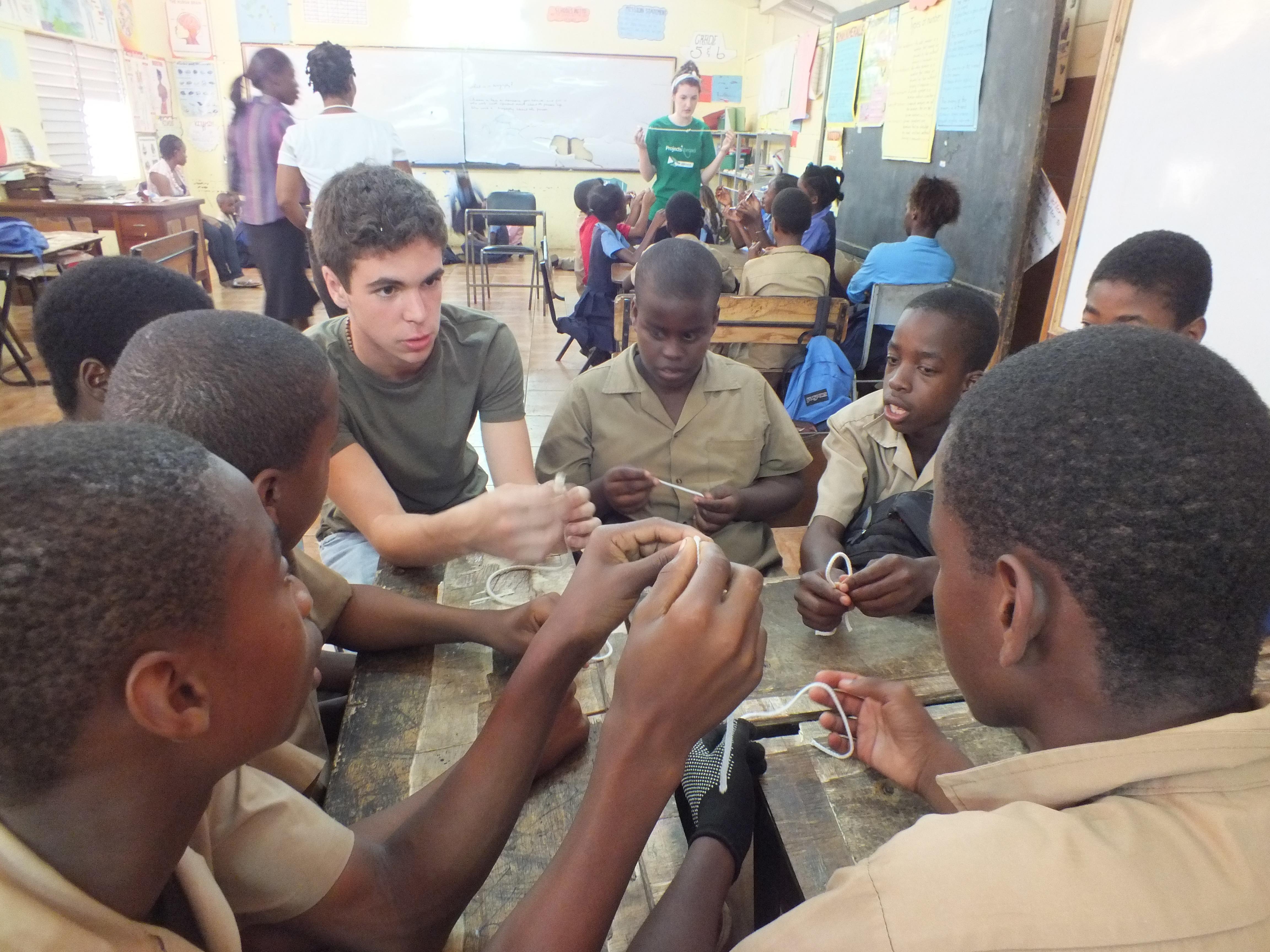 Students in Jamaica learn how to tie basic knots from a volunteer teaching in Jamaica A Projects Abroad volunteer teaching life skills to a group of boys at his volunteer teaching placement in Jamaica